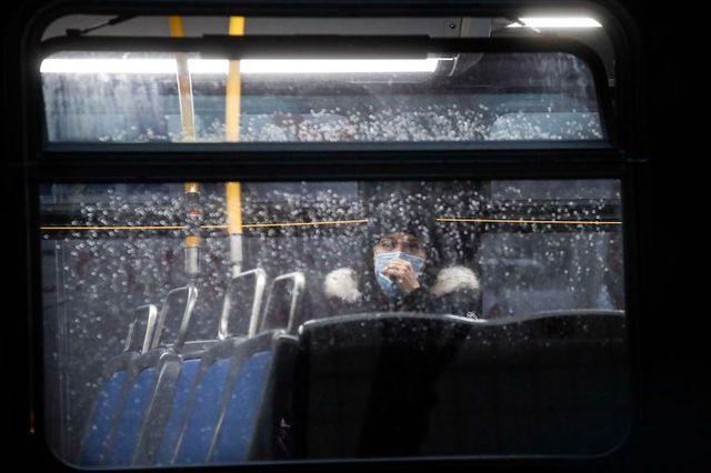 A masked woman sits in a MTA bus during a recent rainfall.
